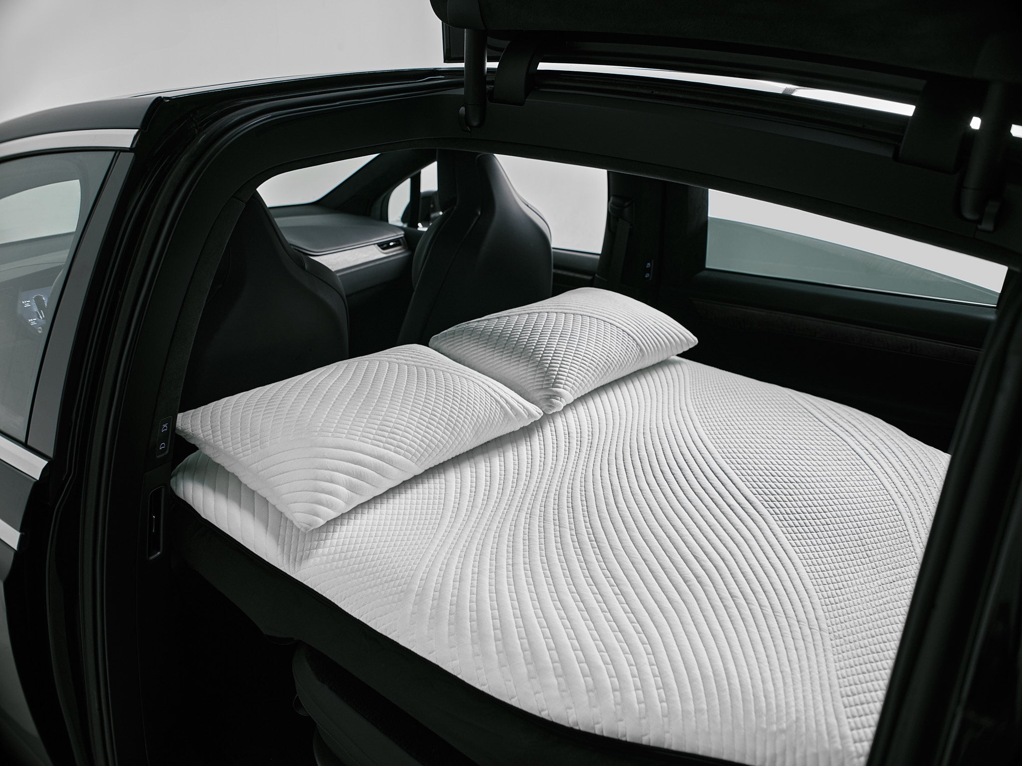 Interior view of Tesla Model X with Snuuzu car mattress and pillows, showing premium comfort design and perfect vehicle fit.